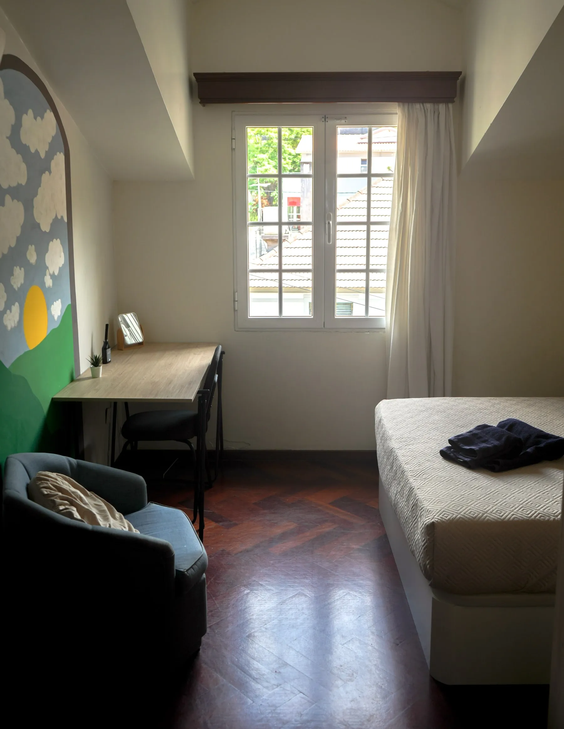 Orecchiette bed, desk and armchair beside the window