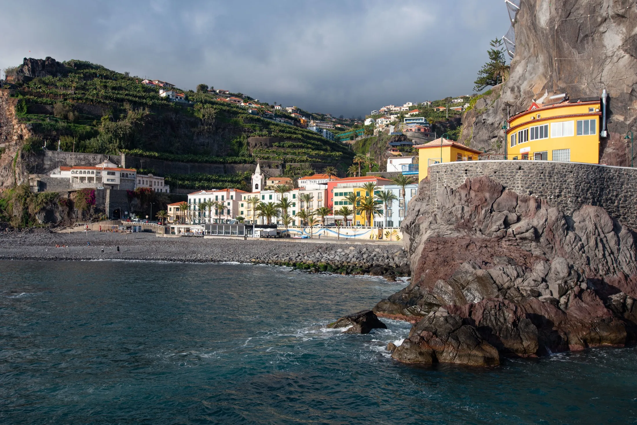 A coastal village beneath green cliffs on Madeira